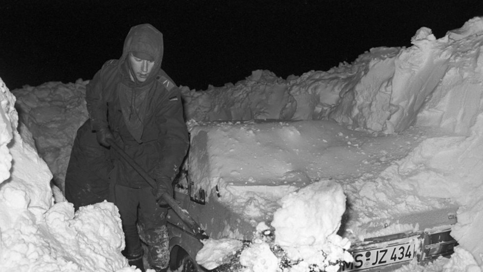 Ein Mann befreit in Hamburg sein Auto mit einer Schaufel von den Schneemassen.Foto: dpa