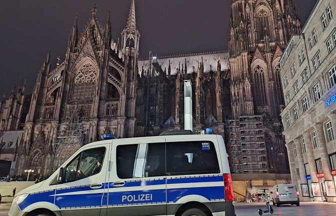 Ein Einsatzfahrzeug der Polizei steht vor dem Dom.<span class='image-autor'>Sascha Thelen/dpa</span>