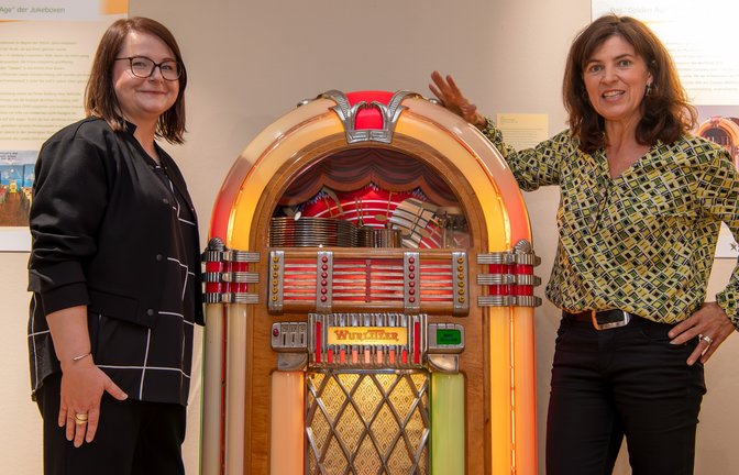 Posieren mit dem Prachtstück der Ausstellung: Jessica Midding (links) vom Deutschen Automatenmuseum und Dr. Claudia Papp, Leiterin des Stadtmuseums, mit einer „Wurlitzer“ von 1947.  <span class='image-autor'>Foto: Kalb</span>