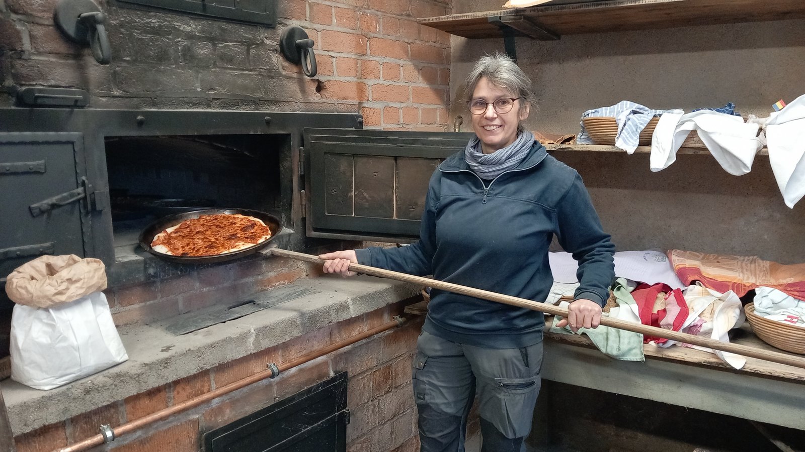 Annette Gummer-Rimmele aus Ochsenbach zieht die erste Pizza aus dem Ofen des Backhauses.  Foto: Glemser