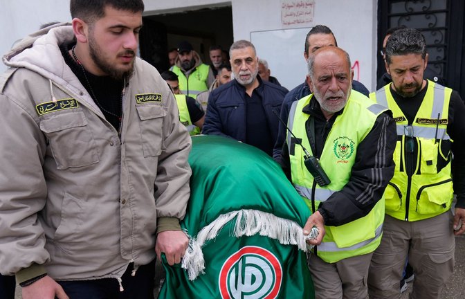 Libanesische Sanitäter tragen den Leichnam eines Kameraden, der bei einem israelischen Luftangriff getötet wurde – die humanitäre Katastrophe geht im Nahost-Krieg unter.<span class='image-autor'>Foto: Hussein Malla/dpa</span>