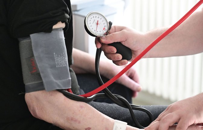 Ein Pfleger misst in einem Krankenhaus auf einer Station bei einem Patienten den Blutdruck.<span class='image-autor'>Foto: Bernd Weißbrod/dpa</span>
