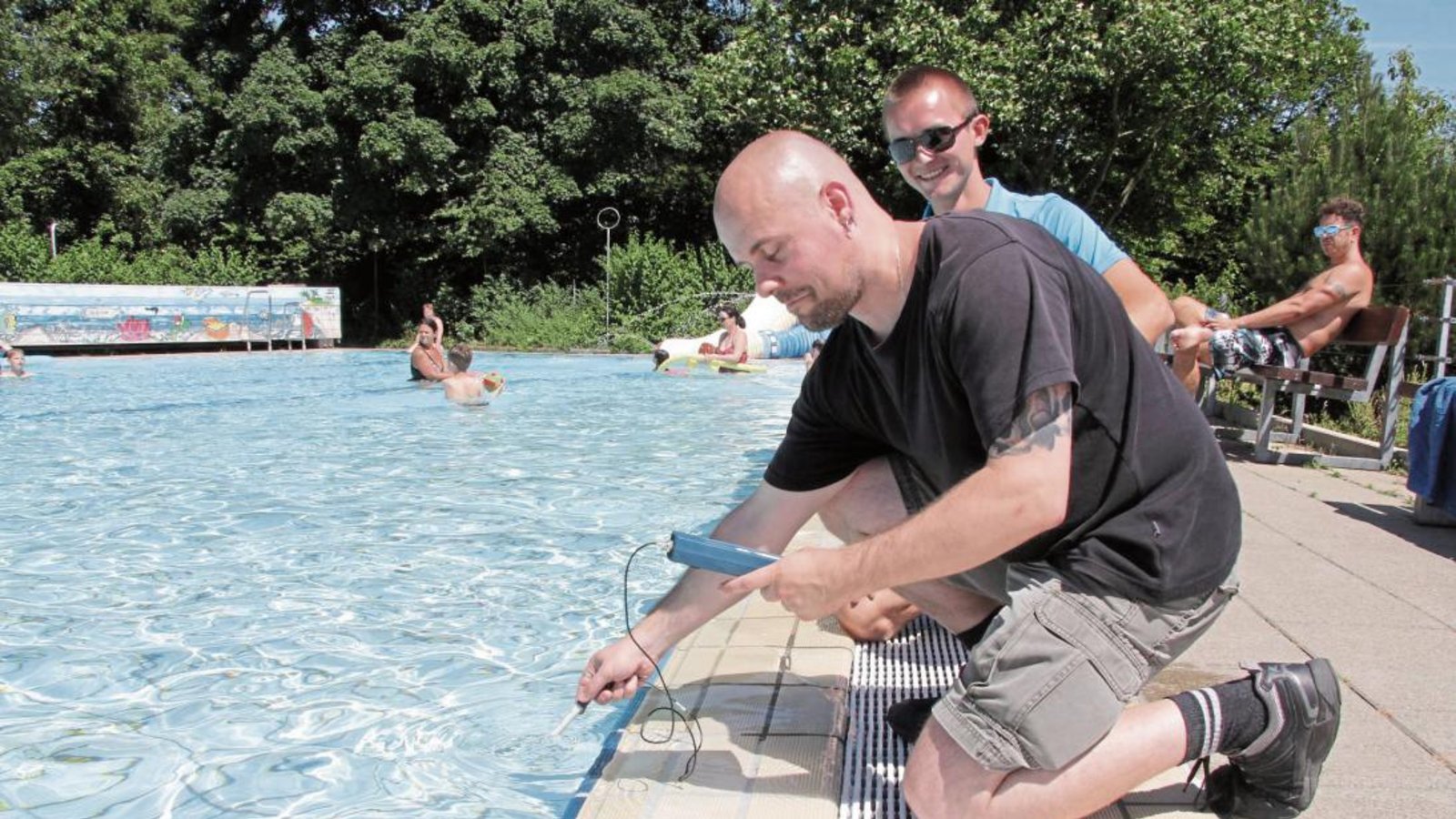 VKZ-Redakteur Michael Banholzer beim Bestimmen von Wassertemperatur und PH-Wert. Der stellvertretende Bäderleiter Klaus Bißler (dahinter) passt auf, dass alles korrekt vor sich geht. Foto: Schuhmacher VKZ-Redakteur Michael Banholzer beim Bestimmen von Wassertemperatur und PH-Wert. Der stellvertretende Bäderleiter Klaus Bißler (dahinter) passt auf, dass alles korrekt vor sich geht. Foto: Schuhmacher
