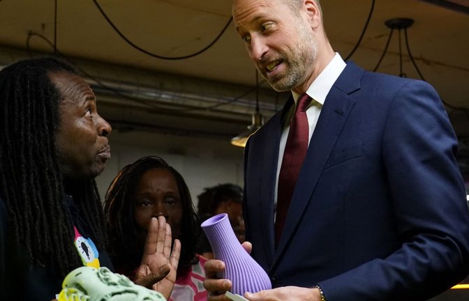 Der britische Prinz William hält eine 3D-gedruckte Vase in der Hand, als er sich am 14. Oktober 2026 in London mit Stipendiaten und ehemaligen Stipendiaten von „The Amos Bursary“ trifft. „The Amos Bursary“ wurde 2009 von Baronin Valerie Amos und Colleen Amos gegründet und ist eine Wohltätigkeitsorganisation, die leistungsstarke junge Menschen afrikanischer und karibischer Herkunft fördert.<span class='image-autor'>ALBERTO PEZZALI/afp</span>