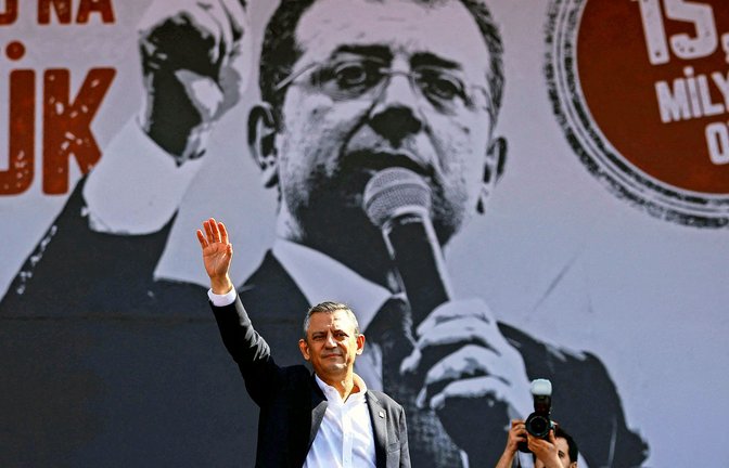Der CHP-Vorsitzende Özgür Özel winkt Anhängern auf der Demo in Istanbul. Auf dem Plakat im Hintergrund ist der inhaftierte CHP-Politiker Ekrem Imanoglu  zu sehen.<span class='image-autor'>Foto: AFP/KEMAL ASLAN</span>