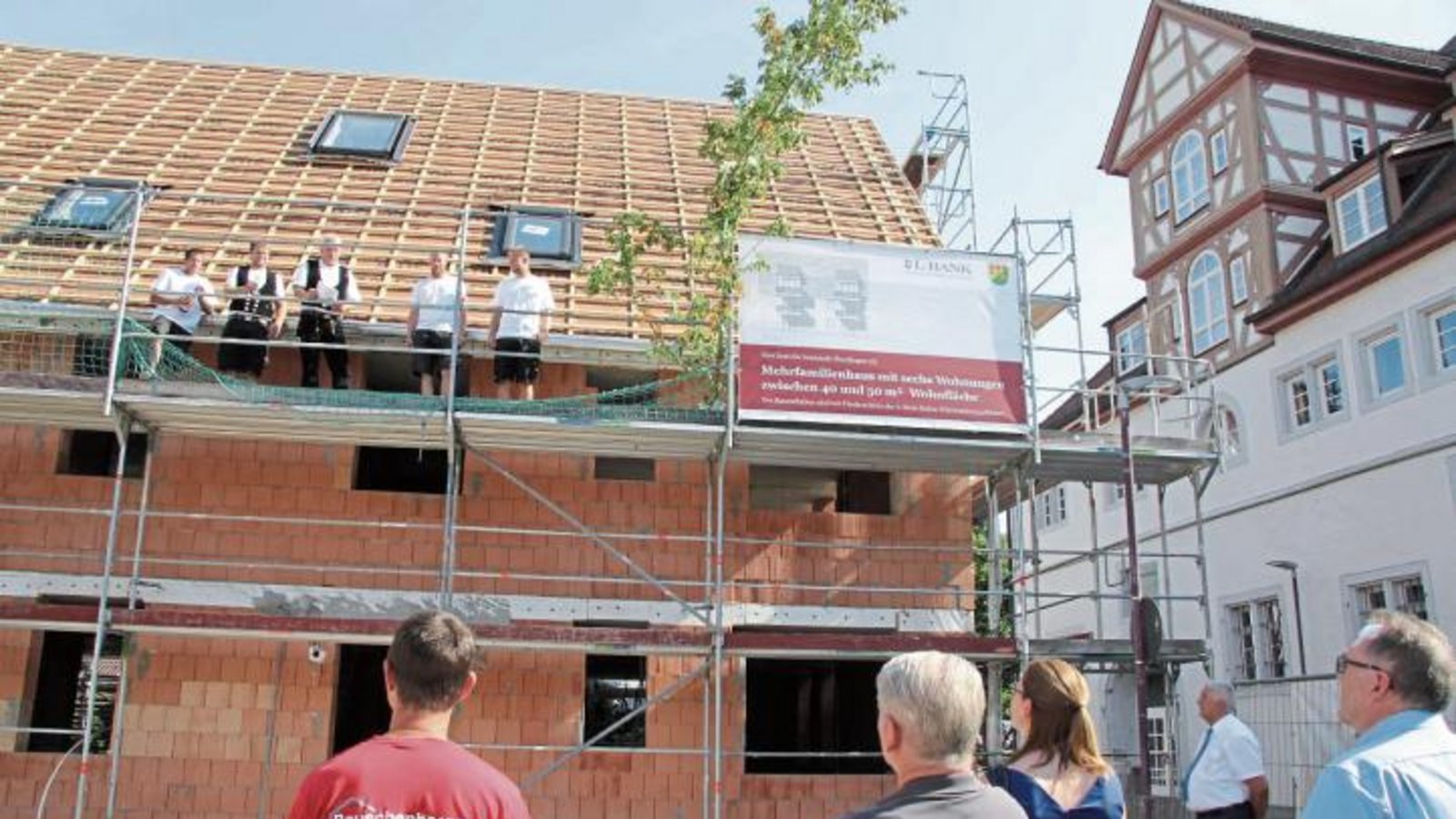 Zimmermeister Stefan Leibfried (auf dem Gerüst in der Mitte) hielt den Richtspruch für den Neubau in unmittelbarer Nähe zum Rathaus, das rechts zu sehen ist. Foto: Banholzer Zimmermeister Stefan Leibfried (auf dem Gerüst in der Mitte) hielt den Richtspruch für den Neubau in unmittelbarer Nähe zum Rathaus, das rechts zu sehen ist. Foto: Banholzer