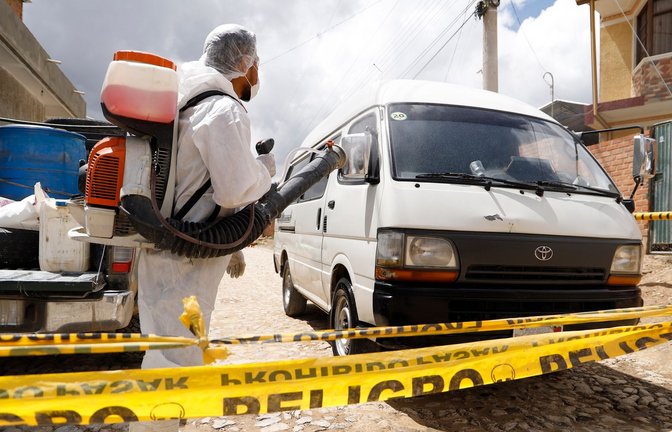 Ein Gesundheitsarbeiter in Schutzkleidung desinfiziert ein Auto in der bolivianischen Stadt Cochabamba. Dort wurde ein Vogelgrippe-Ausbruch festgestellt.<span class='image-autor'>Foto: David Flores/dpa</span>