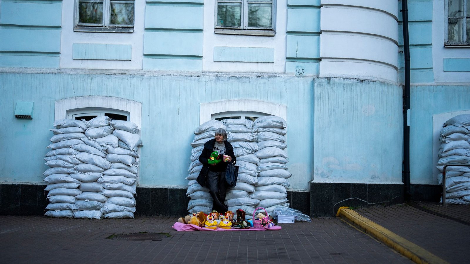 Kiew ist eine Stadt der Gegensätze geworden: Vor mit Sandsäcken geschützten Fenstern verkauft eine Frau Spielzeug. Die Ukraine verteidigt sich nun seit 796 Tagen gegen den russischen Angriffskrieg.Foto: Francisco Seco/AP/dpa