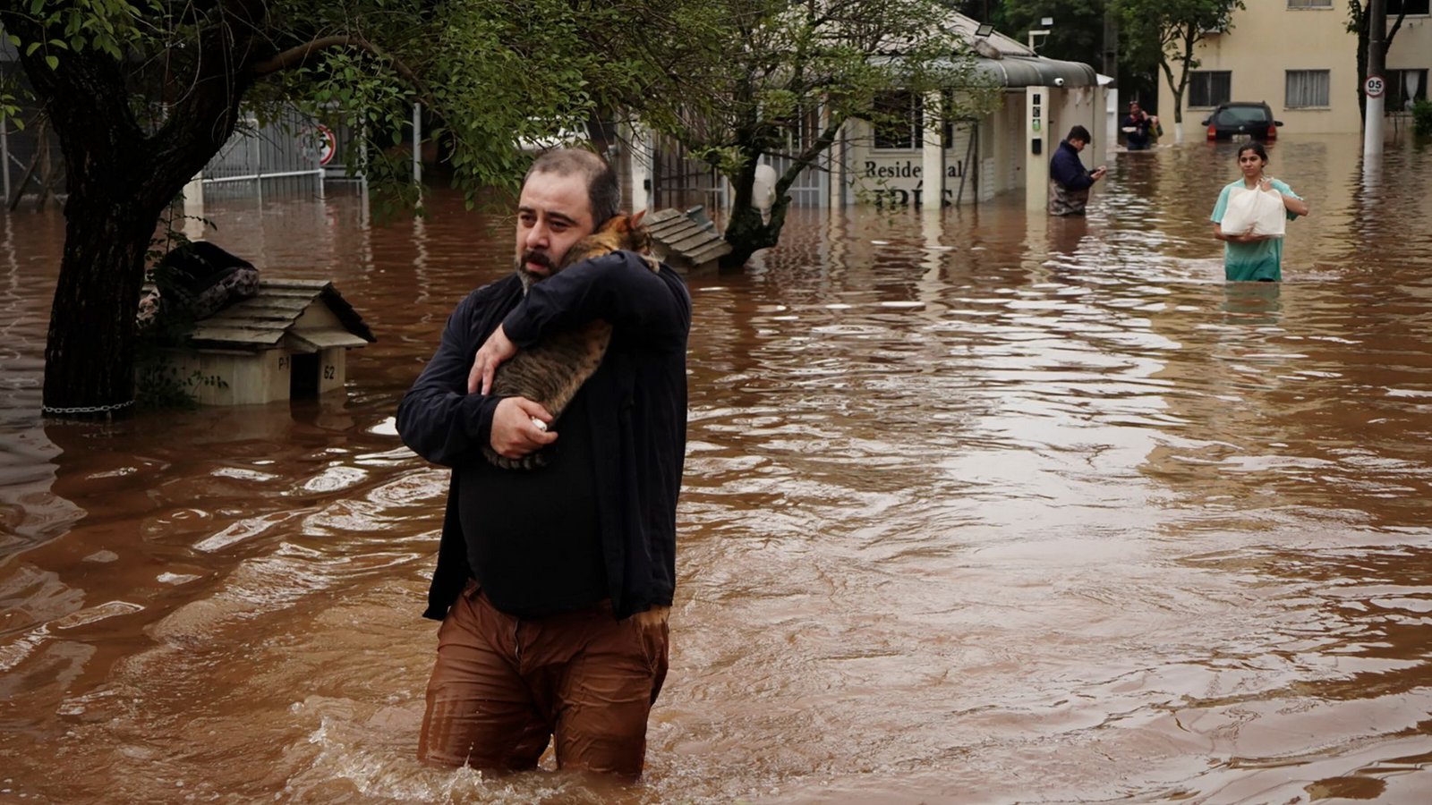 Ein Mann watet durch eine überschwemmte Straße in Brasilien.Foto: Carlos Macedo/AP