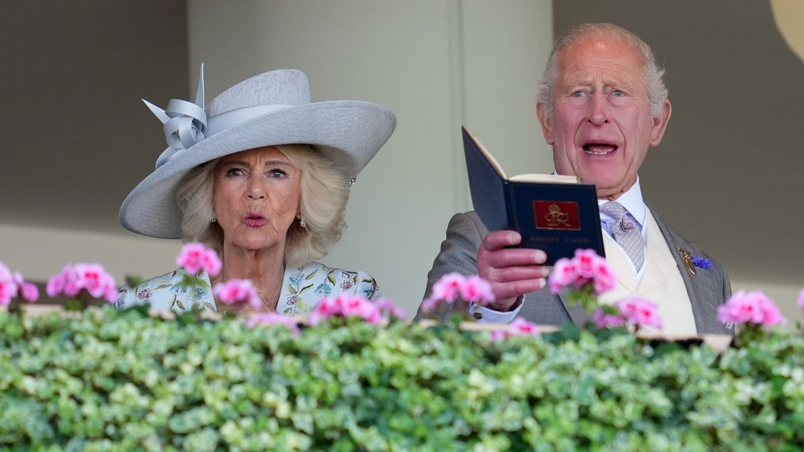 Königin Camilla setzt am ersten Tag von Royal Ascot auf einen klassisch-eleganten Look: einen breitkrempigen hellgrauen Hut mit skulpturaler Schleifendekoration, kombiniert mit einem hellen, floral bestickten Outfit.Foto: picture alliance/dpa/AP | Kin Cheung