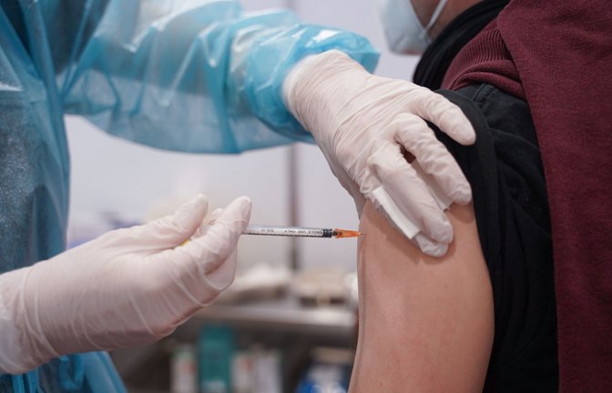 Ein junger Mann wird mit einer Booster-Dosis eines Corona-Impfstoffs in einem Impfzentrum in Potsdam gegen das Coronavirus geimpft.<span class='image-autor'>Foto: dpa/Jörg Carstensen</span>