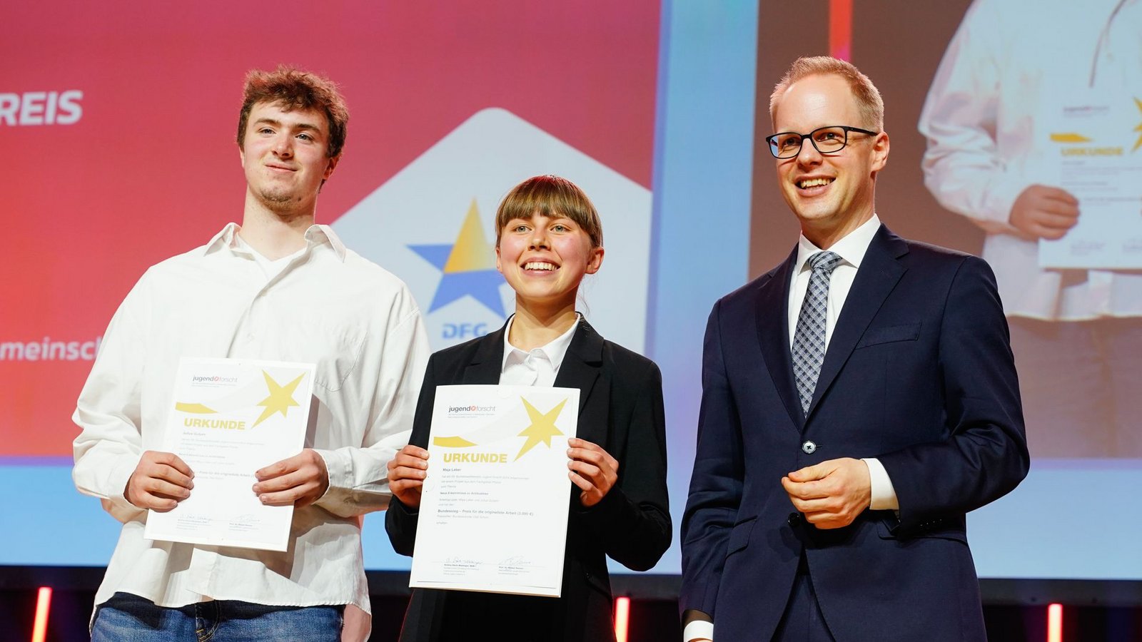 Maja Leber und Julius Gutjahr, Sieger beim Preis des Bundeskanzler, stehen bei der Siegerehrung zum 59. „Jugend forscht“-Bundesfinale mit Laudator Jens Brandenburg, Staatssekretär beim Bundesbildungsministerium, auf der Bühne.Foto: Uwe Anspach/dpa/Uwe Anspach Maja Leber und Julius Gutjahr, Sieger beim Preis des Bundeskanzler, stehen bei der Siegerehrung zum 59. „Jugend forscht“-Bundesfinale mit Laudator Jens Brandenburg, Staatssekretär beim Bundesbildungsministerium, auf der Bühne.Foto: Uwe Anspach/dpa/Uwe Anspach