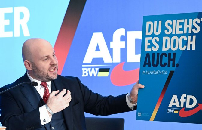 AfD-Landeschef Markus Frohnmaier zeigt eines der AfD-Wahlplakate – angelehnt an die „Stadtbild-Debatte“ des Kanzlers.<span class='image-autor'>Foto: Bernd Weißbrod/dpa</span>