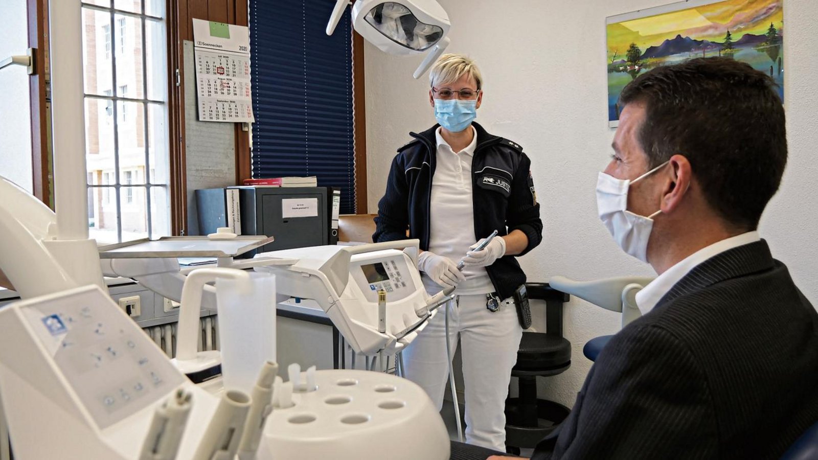 Antje Baier ist zweite stellvertretende Leiterin des Krankenreviers und kümmert sich um die organisatorischen Aufgaben. An Anstaltsleiter Frank Jansen demonstriert sie, wie eine Zahnarztbehandlung hinter Gittern abläuft. Beim „richtigen“ Zahnarzt hätte der Patient natürlich keinen Mundschutz. Foto: Friedrich Antje Baier ist zweite stellvertretende Leiterin des Krankenreviers und kümmert sich um die organisatorischen Aufgaben. An Anstaltsleiter Frank Jansen demonstriert sie, wie eine Zahnarztbehandlung hinter Gittern abläuft. Beim „richtigen“ Zahnarzt hätte der Patient natürlich keinen Mundschutz. Foto: Friedrich