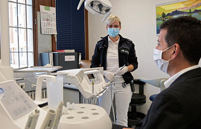 Antje Baier ist zweite stellvertretende Leiterin des Krankenreviers und kümmert sich um die organisatorischen Aufgaben. An Anstaltsleiter Frank Jansen demonstriert sie, wie eine Zahnarztbehandlung hinter Gittern abläuft. Beim „richtigen“ Zahnarzt hätte der Patient natürlich keinen Mundschutz.  Foto: Friedrich