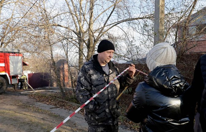 Anwohner stehen im russischen Stanowoje vor einem Haus, das durch ukrainische Drohnen beschädigt wurde.<span class='image-autor'>Foto: AFP/Tatjana Makejewa</span>