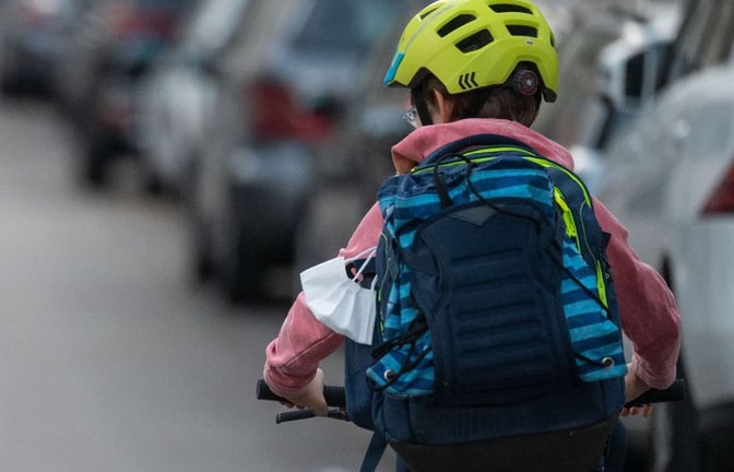 Ein Schulkind fährt mit seinem Fahrrad eine Straße entlang.<span class='image-autor'>Marijan Murat/dpa</span>