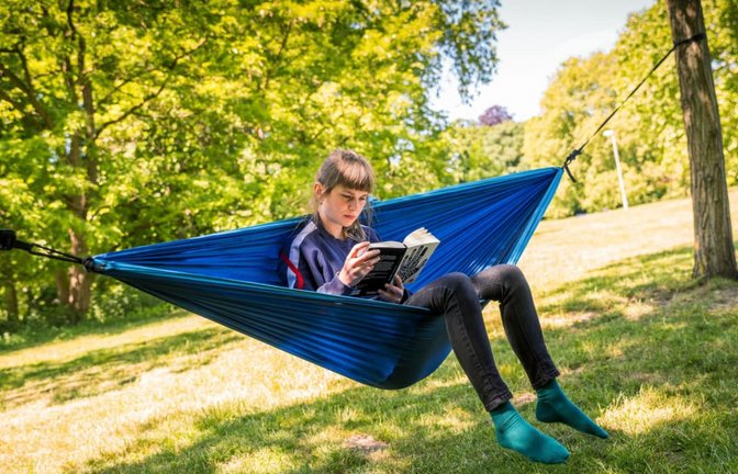 Schönste Ferienbeschäftigung: Lesen? Das wollen zumindest Reiseanbieter unterstützen. Doch für die jüngere Generation sehen die Zahlen ganz anders aus.<span class='image-autor'>Moritz Frankenberg/picture alliance/dpa</span>