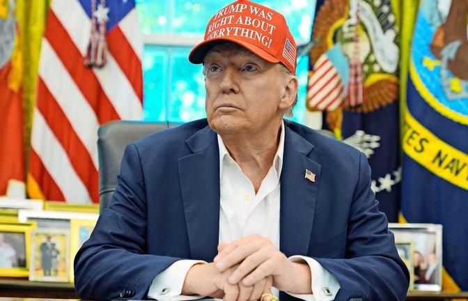 Donald Trump an seinem Schreibtisch im Weißen Haus: Er trägt eine Kappe mit der Aufschrift: „Trump hatte in allem recht!"<span class='image-autor'>Foto: Jacquelyn Martin/AP/dpa</span>