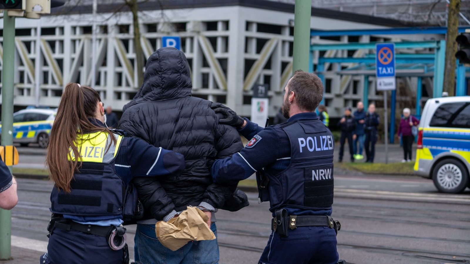 Einsatzkräfte der Polizei führen einen Mann in der Nähe von einem Tatort in Handschelllen ab.Foto: dpa/Christian Mathiesen