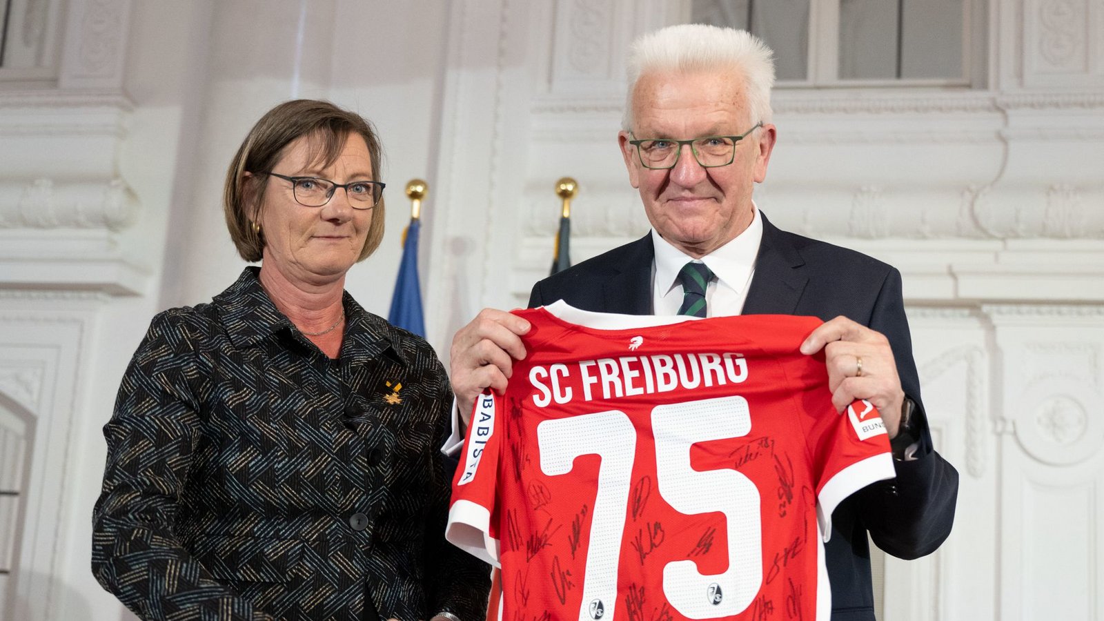 Winfried Kretschmann ist  VfB-Fan. Über das Freiburg- Trikot von Parteifreundin Edith Sitzmann freut er sich trotzdem.Foto: dpa/Marijan Murat
