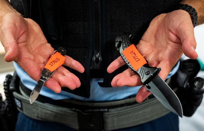 Ein Bundespolizist zeigt am Hauptbahnhof sichergestellte Messer.<span class='image-autor'>dpa/Daniel Bockwoldt</span>