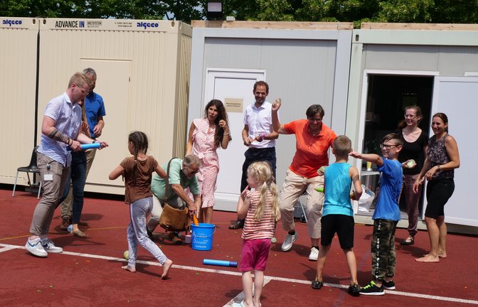 Vertreter von Landratsamt, Berufsschule, Stadt und Diakonie entdecken das Kind in sich: Bei den Wasserspielen nach dem offiziellen Pressegespräch hatten alle viel Spaß mit den ukrainischen Flüchtlingskindern, die derzeit in Mühlacker untergebracht sind.  <span class='image-autor'>Foto: Friedrich</span>