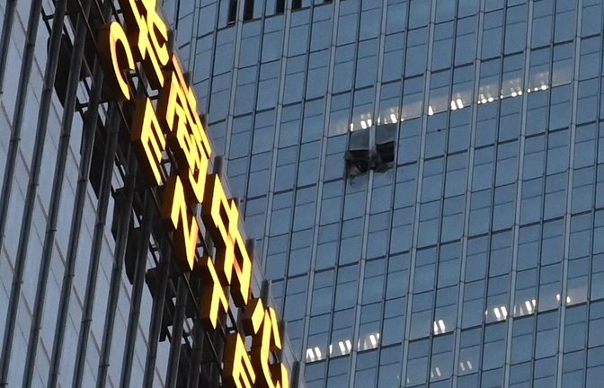 Das Loch an der Fassade des China Zun befand sich in den oberen Etagen.<span class='image-autor'>Foto: Johannes Neudecker/dpa</span>