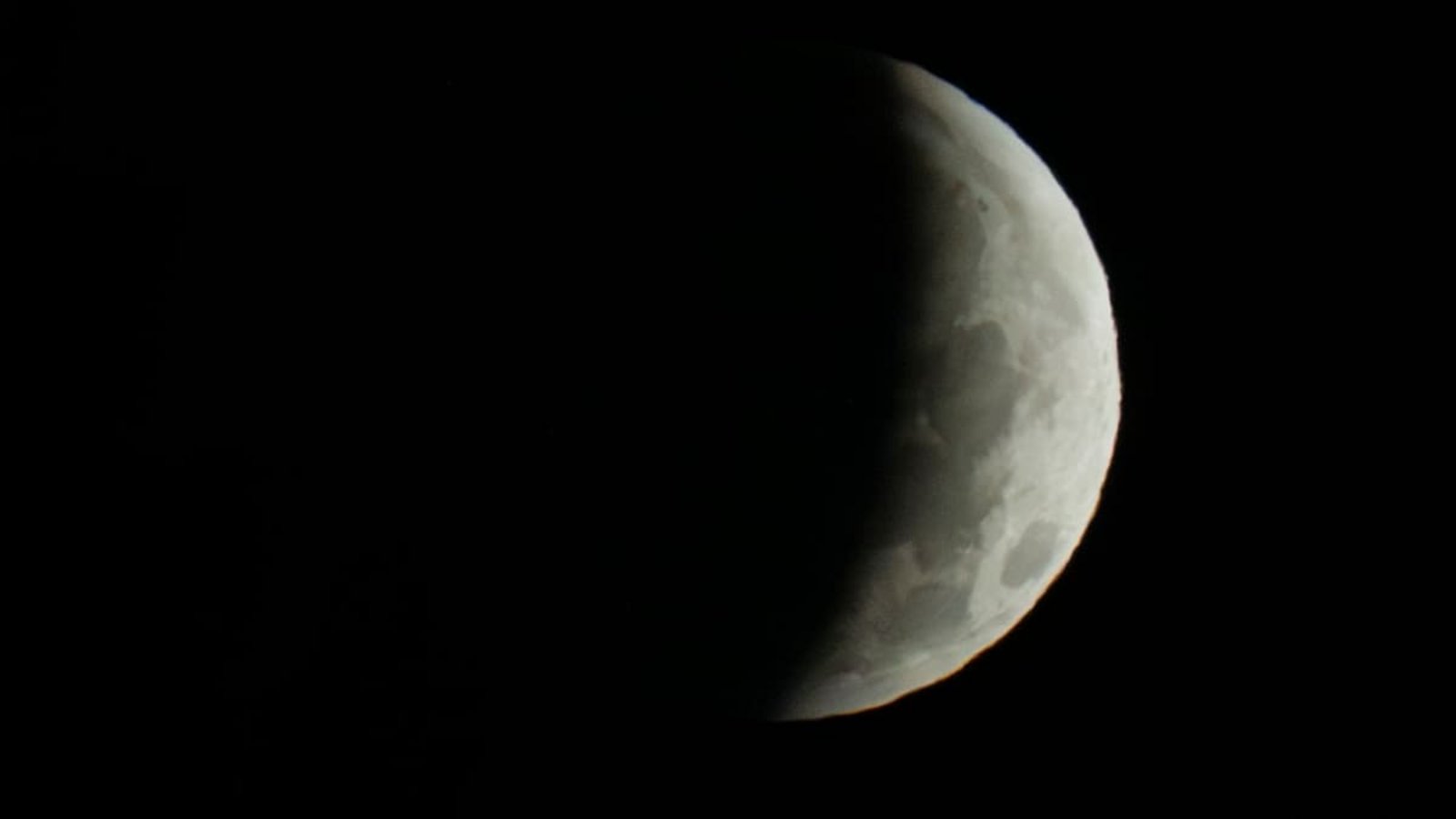 Nur noch eine Sichel ist in den frühen Morgenstunden während einer partiellen Mondfinsternis zu sehen.Peter Kneffel/dpa