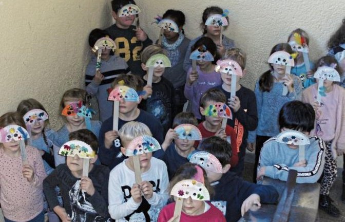 Die Klasse 2c der Vaihinger Schlossbergschule bringt sich mit den selbst gebastelten „venezianischen Masken“ in Faschingsstimmung. Foto: R. Pfisterer