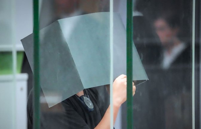 Prozess gegen 32-Jährigen wegen Vergewaltigungen: Der Angeklagte hält sich zum Beginn des Prozesstages im Kriminalgericht Moabit einen Aktenordner vors Gesicht. Der 32-Jährige hat laut Urteil eine Frau mehrfach im Schlaf missbraucht (Archivfoto).<span class='image-autor'>Soeren Stache/dpa</span>