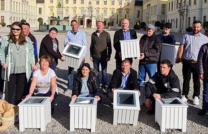 Beschäftigte der Vinzenz-von-Paul-Werkstatt der Stiftung Haus Lindenhof aus Schwäbisch Gmünd haben für das Residenzschloss Ludwigsburg neue Müllbehälter angefertigt. Die Behälter sorgen laut Schlösserverwaltung nun dafür, dass der historische Schlosshof sauber bleibt und sich die zahlreichen Besucherinnen und Besucher weiterhin wohlfühlen. Mit diesem Auftrag hat die Schlossverwaltung Ludwigsburg bewusst eine gemeinnützige Einrichtung aus der Region unterstützt, die alte Menschen und Menschen mit Behinderung fördert. Stephan Hurst, der Leiter der Schlossverwaltung Ludwigsburg, erläutert: „Da unsere bisherigen Müllbehälter in die Jahre gekommen waren, haben wir uns auf die Suche nach einem neuen Produkt gemacht. Dabei sind wir auf die Stiftung Haus Lindenhof gestoßen.“ Die Entscheidung sei dann schnell getroffen worden: „Wir unterstützen gerne gute und qualitativ hochwertige Arbeit. Und wenn damit auch noch ein kirchliches Sozialunternehmen aus der Region gefördert wird, das sich aktiv für die Gesellschaft einsetzt, freut es uns umso mehr.“ Die Stiftung Haus Lindenhof wurde 1971 von der Diözese Rottenburg-Stuttgart und dem Caritasverband der Diözese ins Leben gerufen. Heute gehören mehr als 100 Angebote an 67 Standorten zur Stiftung Haus Lindenhof. Mit großem Engagement haben die Beschäftigten der Vinzenz-von-Paul-Werkstatt in den vergangenen Monaten die 15 Müllbehälter für das Residenzschloss produziert. Einer der Beschäftigten erzählt: „Die Arbeit hat mir großen Spaß gemacht. Ich war sehr gespannt, wie sich die Mülleimer vor Ort im Schlosshof machen.“ Die Motivation der Werkstatt erläutert Leiter Oliver Baum so: „Als Werkstatt für Menschen mit Behinderung möchten wir den Sozialraum und die Arbeitswelt mitgestalten. Jeder Mensch wird bei uns ganz individuell gefördert. Dabei wollen wir nicht als separiertes Arbeitsangebot fernab der ‚normalen’ Arbeitswelt wahrgenommen werden, sondern zeigen, dass auch unsere Arbeit Teil des großen Ganzen ist. Daher haben wir uns auch sehr über den Auftrag gefreut.“ <span class='image-autor'>Foto: SSG</span>