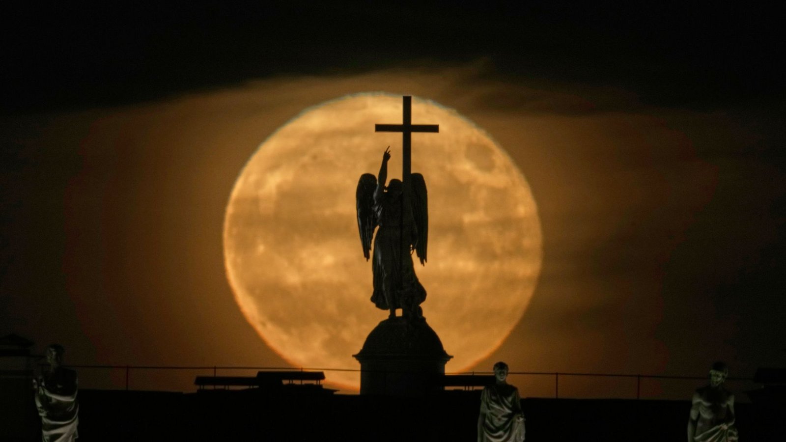 Der Mond geht hinter einer Engelsstatue auf der Alexandersäule auf dem Palastplatz über St. Petersburg auf.Foto: Dmitri Lovetsky/AP/dpa