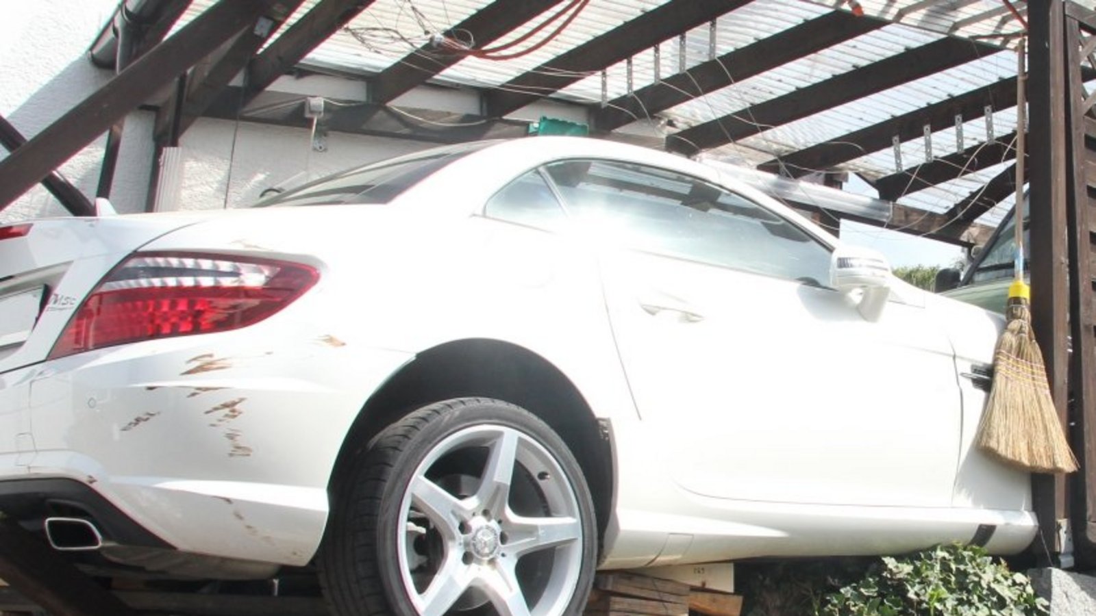 Die Feuerwehr muss den halb in der Luft hängenden Mercedes abstützen.  Foto: Banholzer