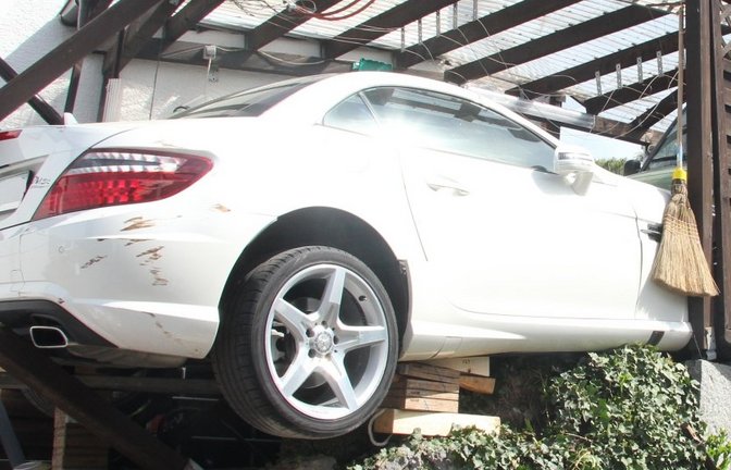 Die Feuerwehr muss den halb in der Luft hängenden Mercedes abstützen.  <span class='image-autor'>Foto: Banholzer</span>