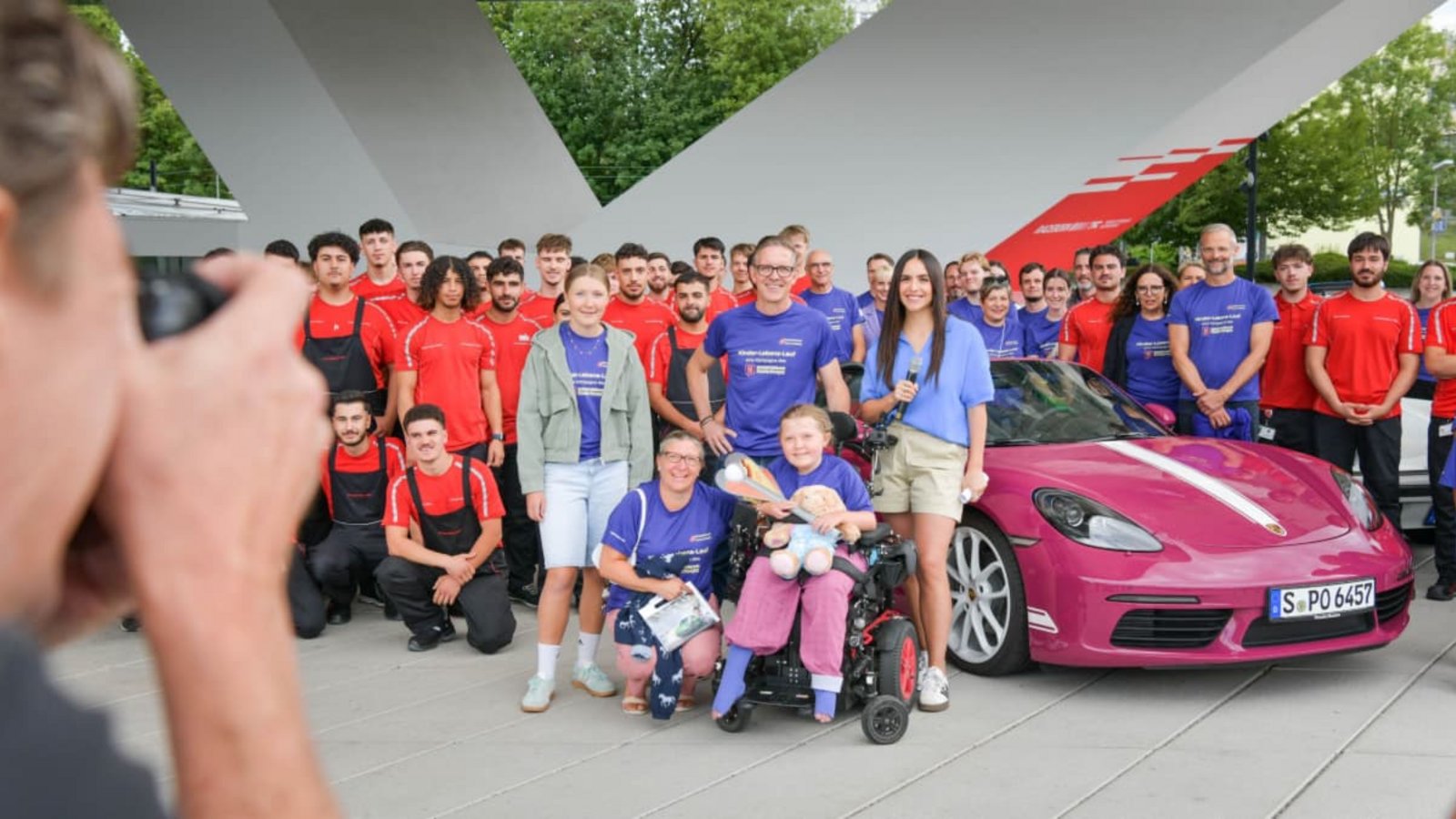 Bitte lächeln: „Starter-Kind“ Mira mit Mitarbeitern und Auszubildenden von Porsche und Porsche-Öffentlichkeitschef Florian Launer (Mitte) vor der Abfahrt des Benefiz-Konvois am Porschemuseum. Der Sportwagenhersteller unterstützt die Aktion des Bundesverbands Kinderhospiz e.V.Lichtgut/Max Kovalenko Bitte lächeln: „Starter-Kind“ Mira mit Mitarbeitern und Auszubildenden von Porsche und Porsche-Öffentlichkeitschef Florian Launer (Mitte) vor der Abfahrt des Benefiz-Konvois am Porschemuseum. Der Sportwagenhersteller unterstützt die Aktion des Bundesverbands Kinderhospiz e.V.Lichtgut/Max Kovalenko