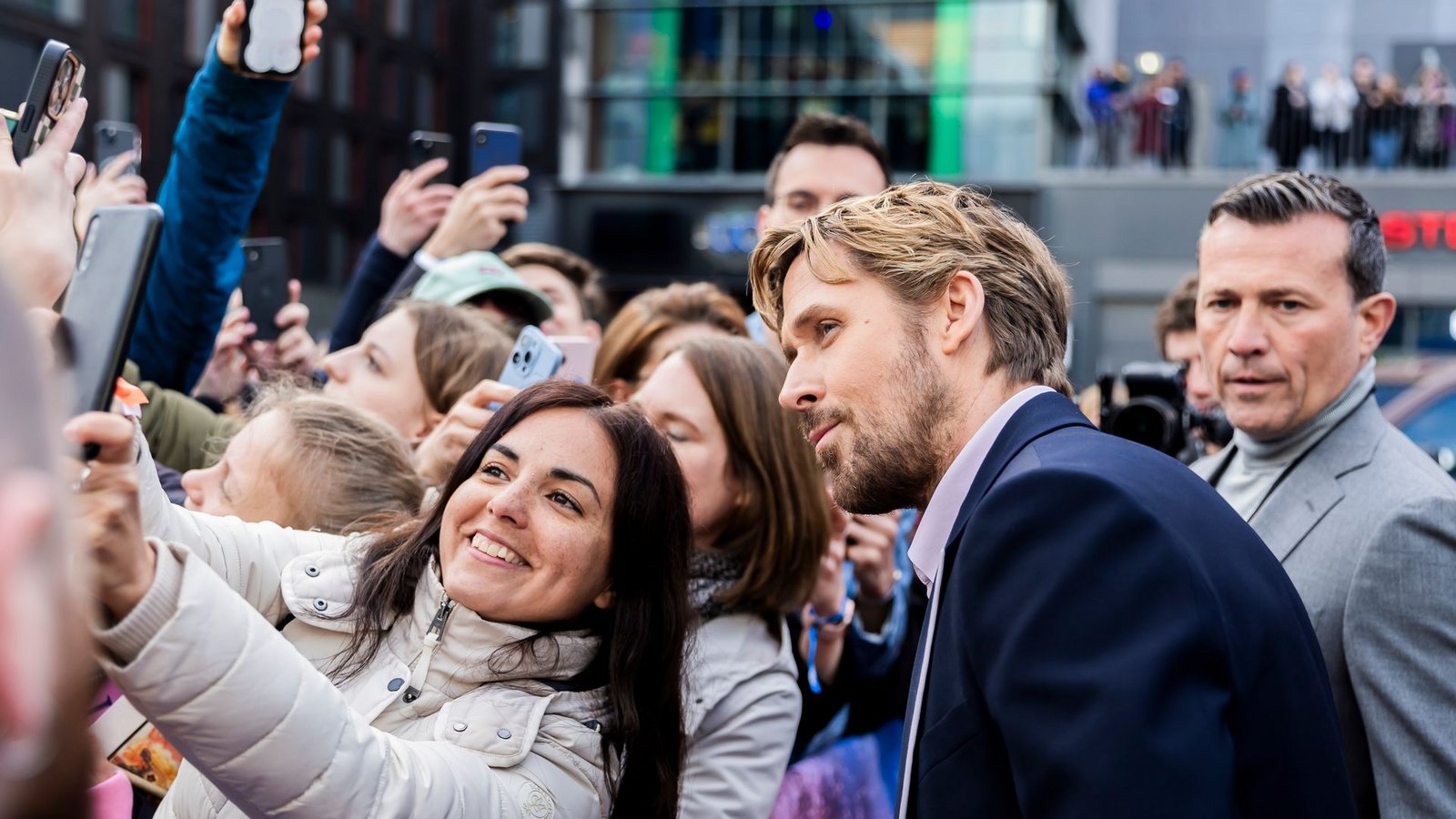 Und auch Ryan Gosling posiert für Selfies mit wartenden Fans.Foto: Christoph Soeder/dpa