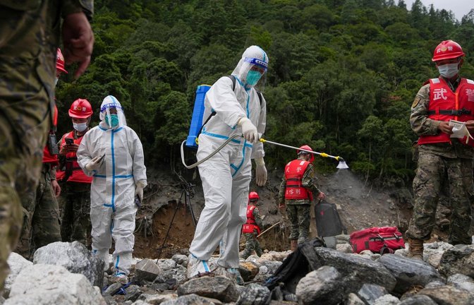 Auf diesem von der Nachrichtenagentur Xinhua veröffentlichten Foto führt ein Arbeiter Desinfektionsarbeiten durch, während Rettungskräfte in einem von der Schlammlawinenkatastrophe betroffenen Gebiet im Kreis Gyirong in der Autonomen Region Tibet im Südwesten Chinas nach Opfern suchen. (zu dpa: «Überall Leichensäcke: Mehr als 1.000 Tote nach Himalaya-Flut»)<span class='image-autor'>Jigme Dorje/Xinhua vía AP/dpa</span>