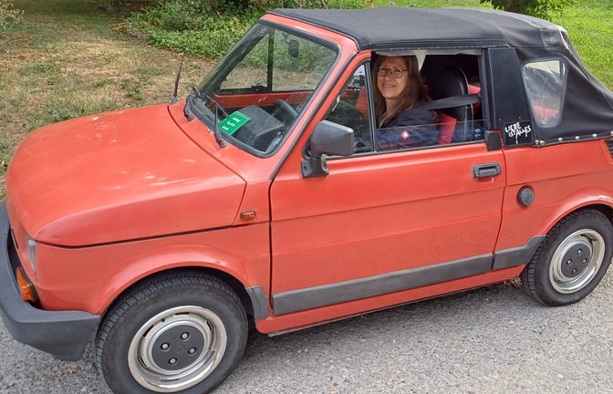 Seit einem Vierteljahrhundert leistet der kleine Fiat 126 Cabrio bei der Familie Straka aus Roßwag seine guten Dienste. 30 Jahre hat das Autole auf dem Buckel, in diesem Fall wohl ein Faltdach, und Fahrerin Brigitte Straka bekommt öfter mal ein „Daumen hoch“ von anderen Verkehrsteilnehmern zu sehen.  <span class='image-autor'>Foto: Rücker</span>