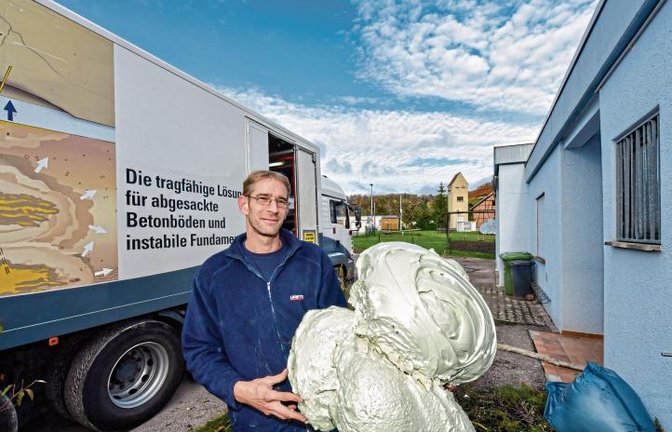 Mit diesem Zweikomponenten-Expansionsharz wird das Fundament des Ochsenbacher Feuerwehrgerätehaus (rechts) diese Woche verfestigt und angehoben. Im Bild Steffen Spreng, der Bauleiter von Uretek, der ausführenden Spezialfirma.  Foto: Kalb
