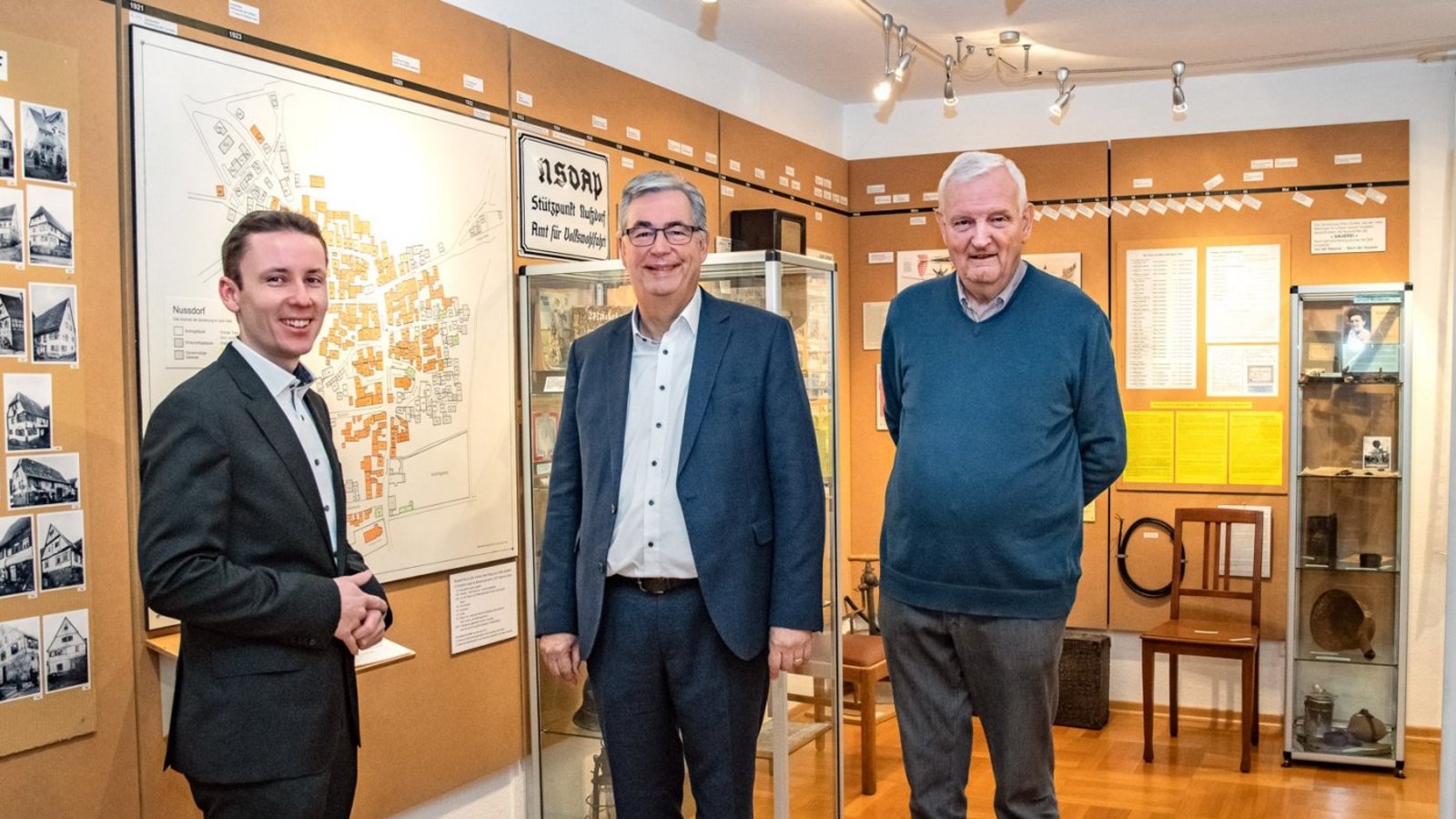 Beim Besuch in Nussdorf steht für Landrat Dietmar Allgaier (Mitte) und Bürgermeister Carsten Willing (links) auch ein Besuch der Ausstellung „Zerstörung und Wiederaufbau von Nussdorf in den Jahren 1945-1954“ mit Erwin Gayer (rechts) auf dem Programm. Foto: LL