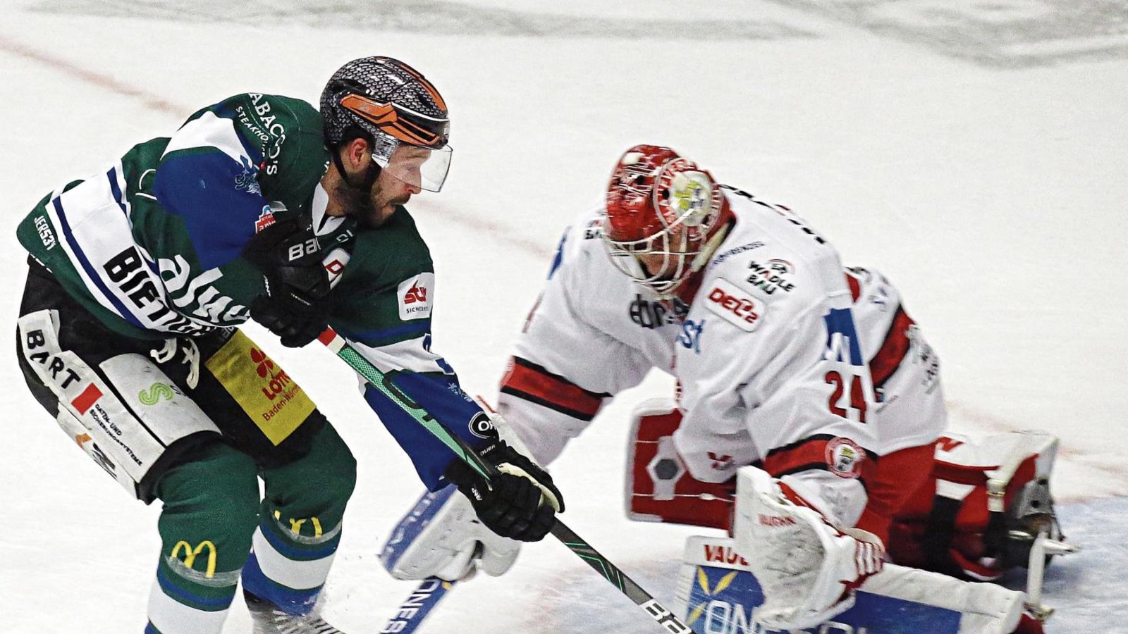 Bietigheims Riley Sheen (links) legt die Hartgummischeibe an Landshuts Goalie Jaroslav Hübl vorbei. Foto: Baumann Bietigheims Riley Sheen (links) legt die Hartgummischeibe an Landshuts Goalie Jaroslav Hübl vorbei. Foto: Baumann