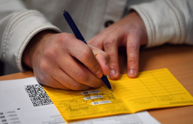 Ein Arzt füllt einen Impfpass in einer kommunal organisierten Impfstelle im thüringischen Jena aus.<span class='image-autor'>Foto: dpa//artin Schutt</span>