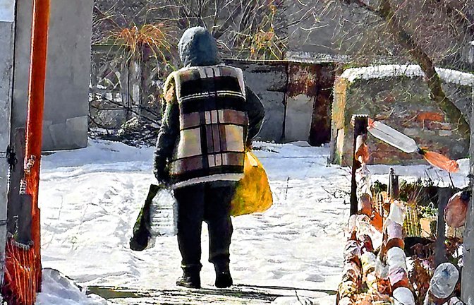 Eine alte Frau trägt im März 2025 ihre kargen Einkäufe aus einem Geschäft nahe des Bahnhofs von Pokrowsk in ihr zehn Kilometer entferntes Haus.<span class='image-autor'>Foto: &nbsp;</span>