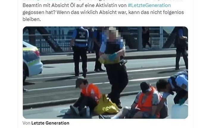 Die Polizistin schüttet dem Aktivisten Öl auf den Kopf.<span class='image-autor'>Foto: Screenshot von X/Ingwar Perowanowitsch</span>
