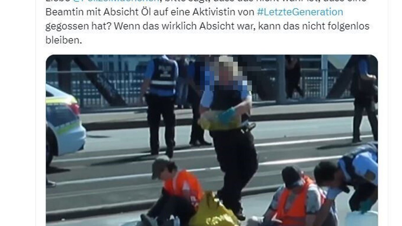 Die Polizistin schüttet dem Aktivisten Öl auf den Kopf.Foto: Screenshot von X/Ingwar Perowanowitsch Die Polizistin schüttet dem Aktivisten Öl auf den Kopf.Foto: Screenshot von X/Ingwar Perowanowitsch
