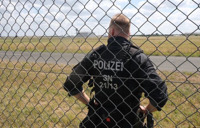 Ein Polizist steht auf dem Gelände des Flughafens Leipzig/Halle.<span class='image-autor'>Sebastian Willnow/dpa</span>
