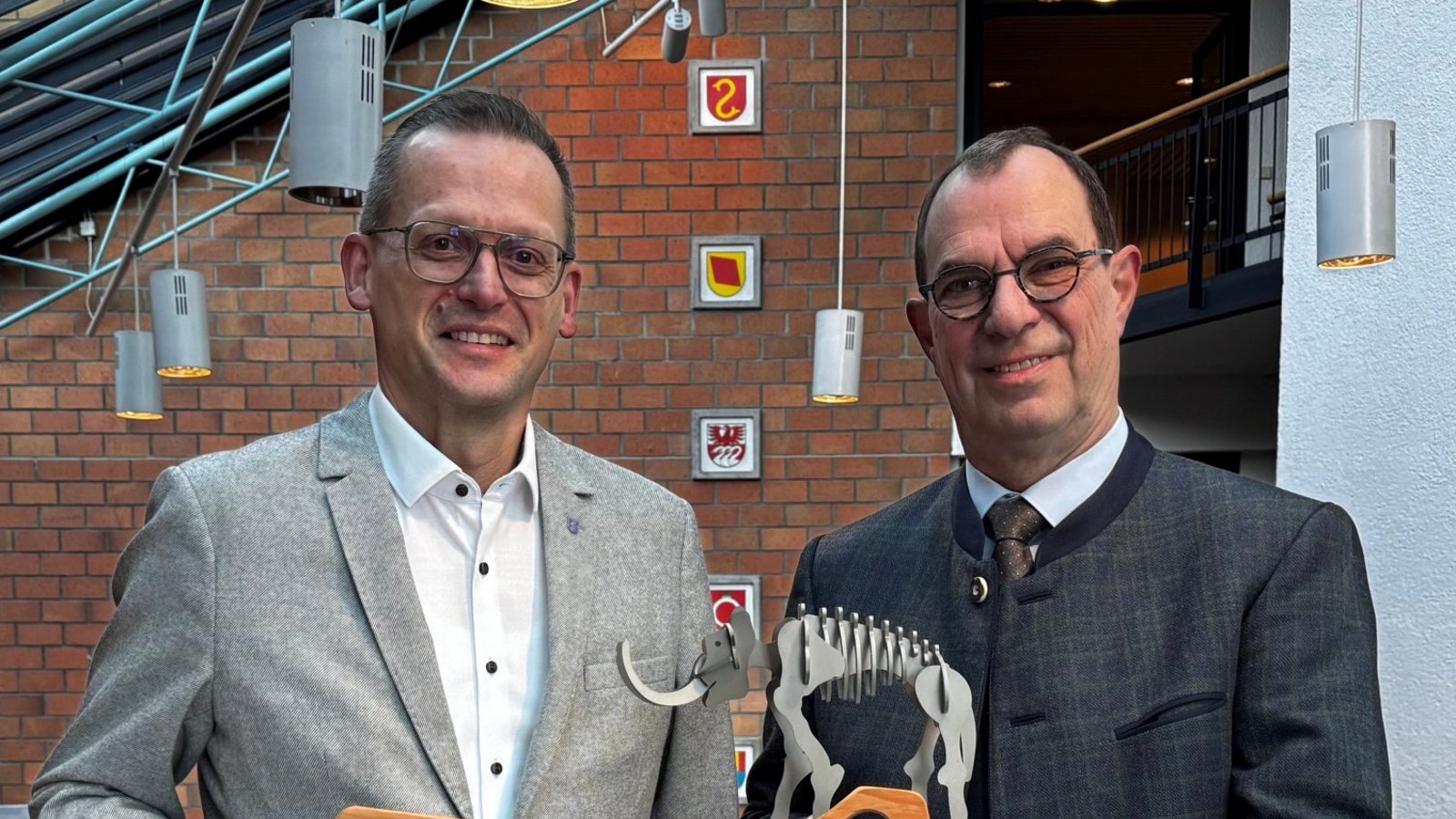 Übergabe im Rathaus in Mühlacker: Der neue OB Stephan Retter (links) erhält von seinem Amtsvorgänger Frank Schneider den symbolischen Schlüssel zur Stadt. Im Gegenzug gibt es als Abschiedsgeschenk ein Modell des Steinheimer Steppenelefanten „Steppi“.  Foto: p