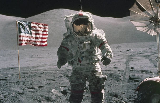 Der US-Astronaut Eugene Cernan steht auf dem Mond (1972), im Hintergrund die US-Fahne.<span class='image-autor'>Foto: Ron Evans/NASA/dpa</span>