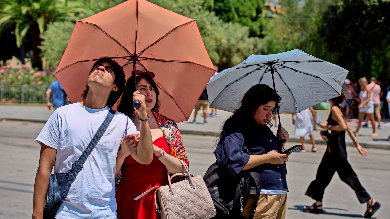 Touristen schützen sich an einem heißen Tag mit Regenschirmen vor der Sonne (Symbolfoto).Foto: Emilio Morenatti/AP/dpa/Emilio Morenatti Touristen schützen sich an einem heißen Tag mit Regenschirmen vor der Sonne (Symbolfoto).Foto: Emilio Morenatti/AP/dpa/Emilio Morenatti